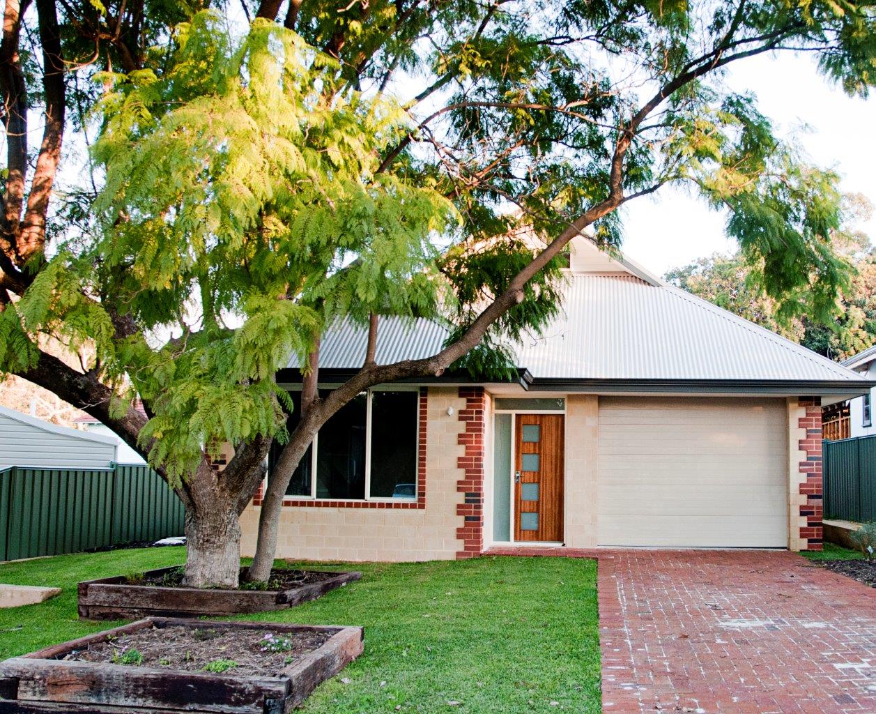 A character home with brick detailing and a leafy front garden built by Zenecon